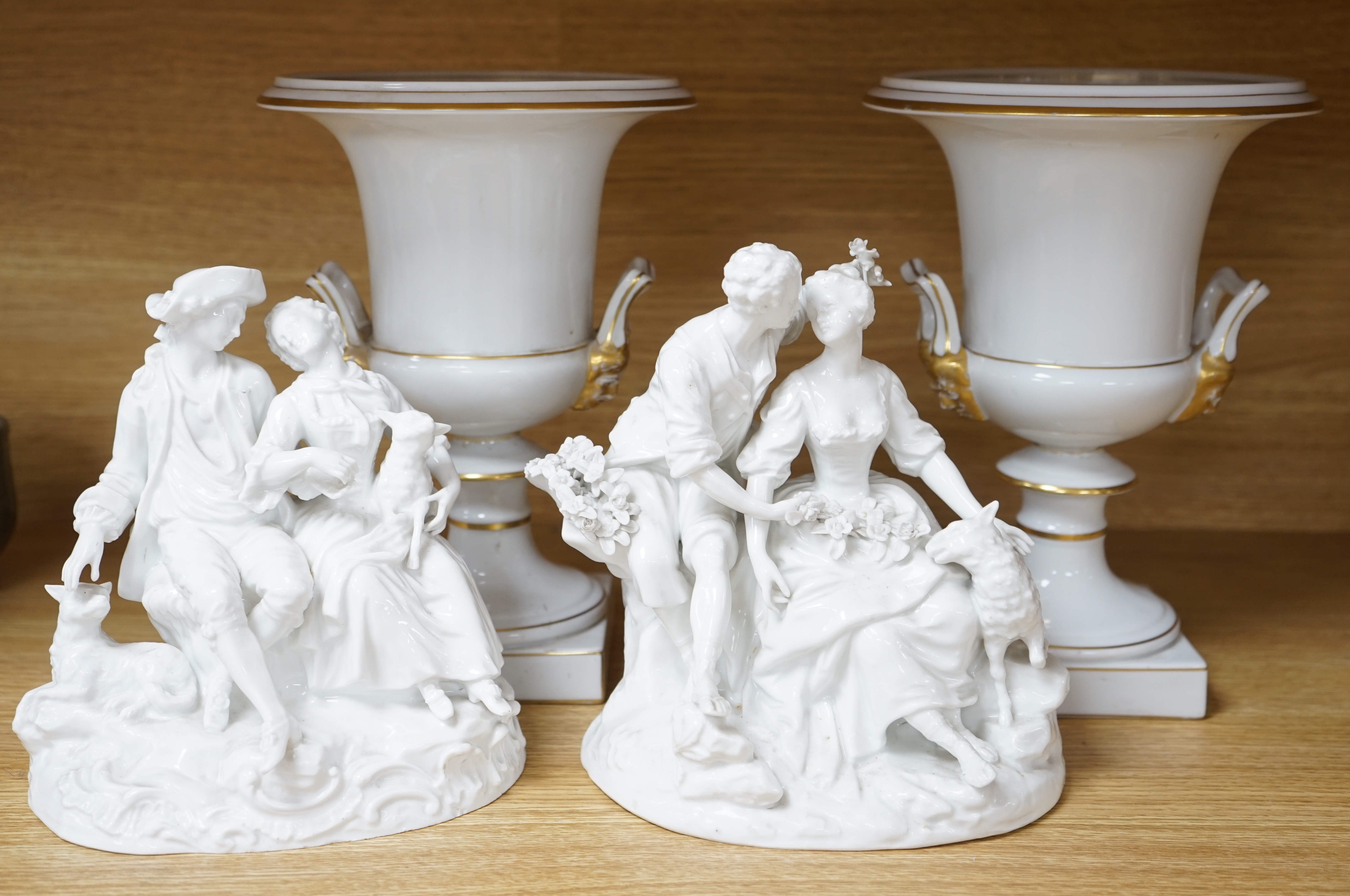 Two Meissen style figure groups, tallest 21cm, and a pair of urns, 26.5cm.